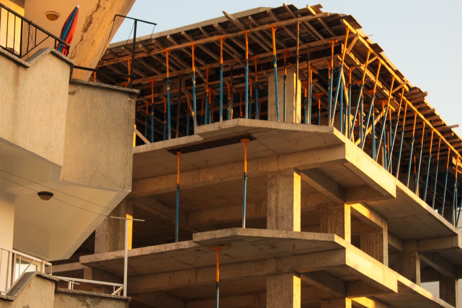 Concrete structure under construction in golden-hour light, formwork and shoring in place